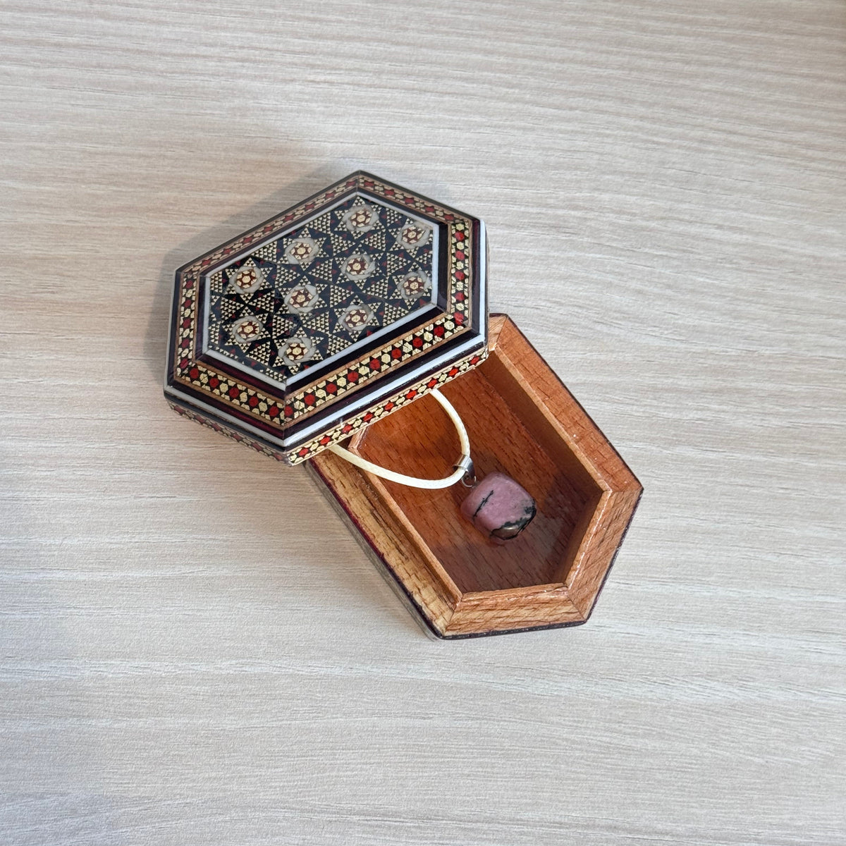 Coffret cadeau FIROUZ ART avec collier en rhodonite, coffret Khatam artisanal et carte personnalisée.
